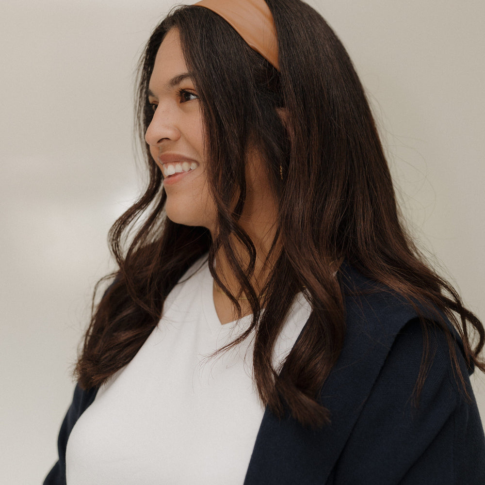 Woman wearing a brown headband with a neutral background