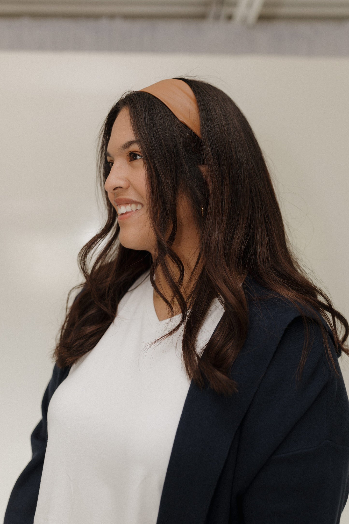 Woman wearing a brown headband with a neutral background