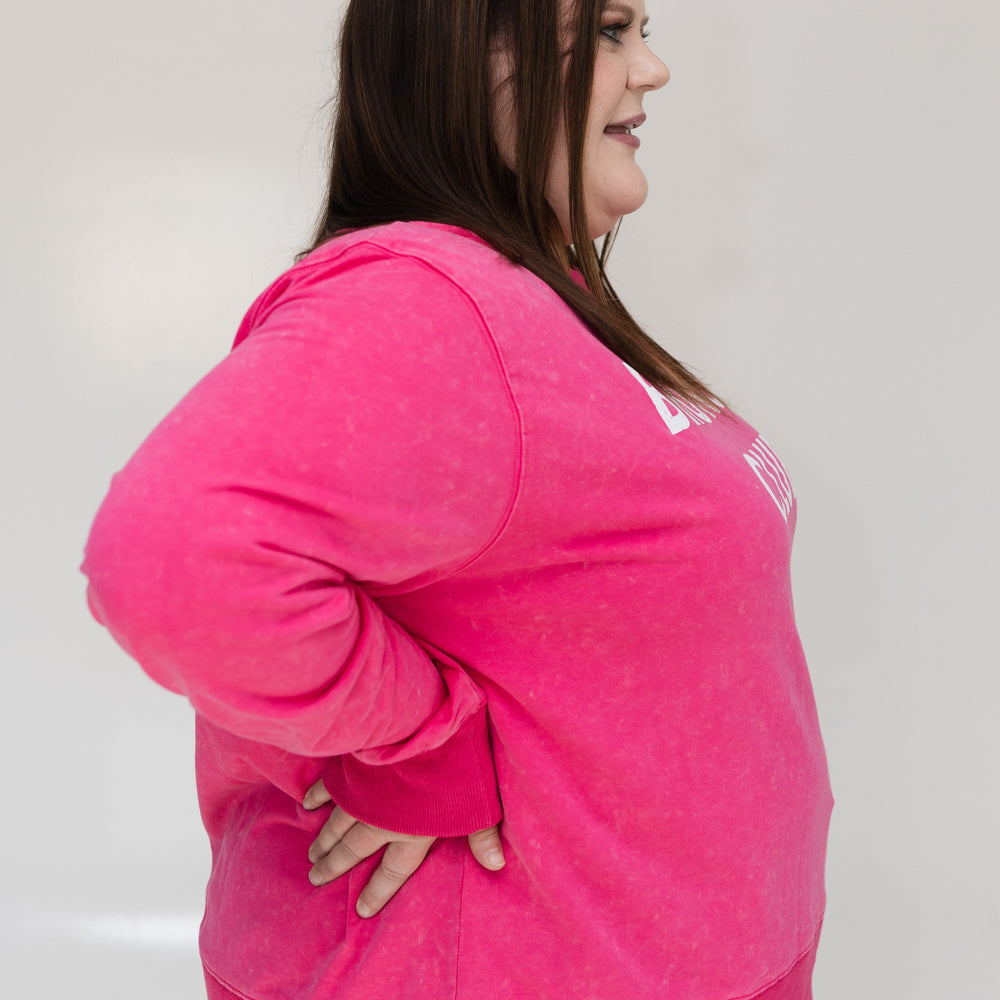 Person wearing a bright pink hoodie against a plain background