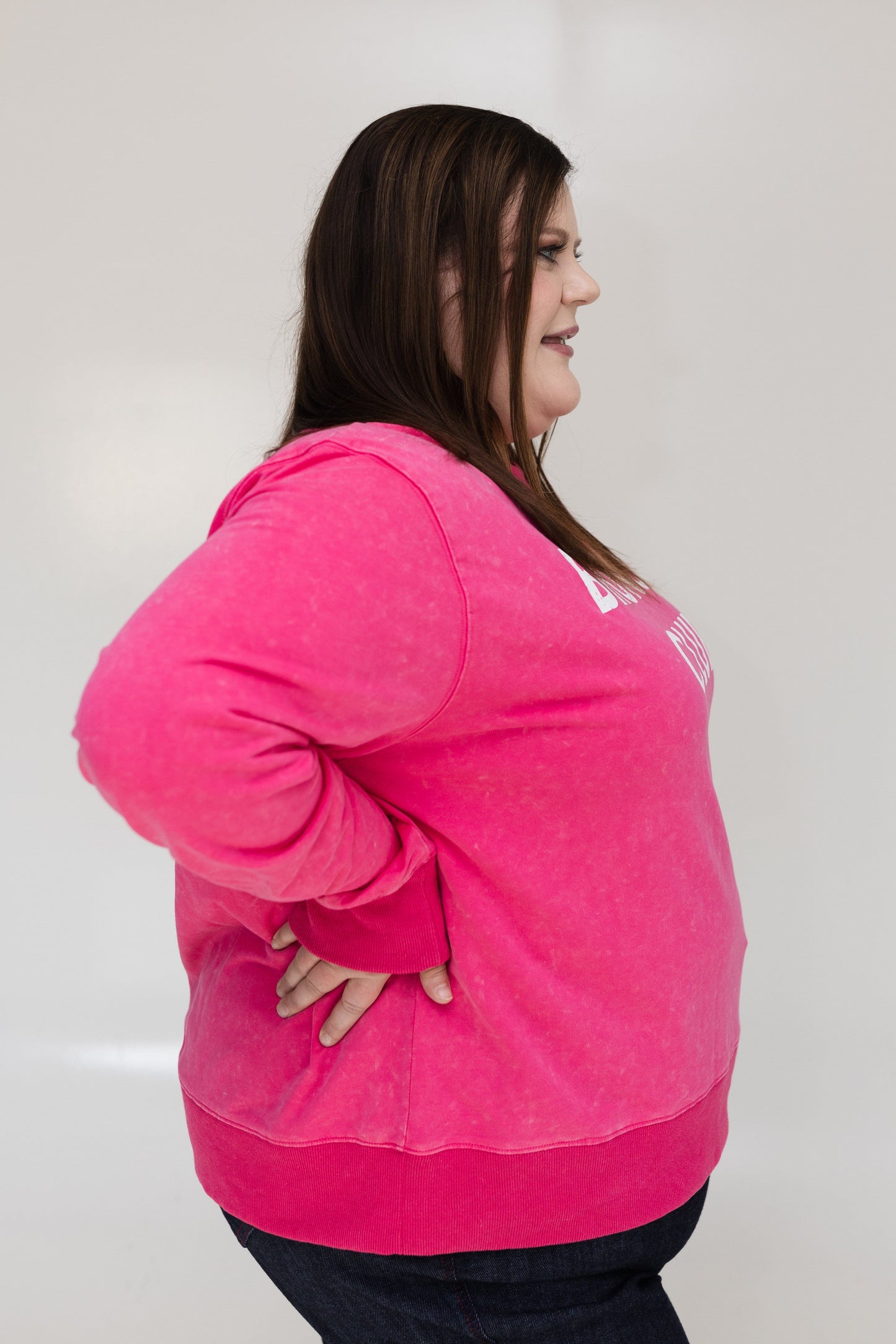 Person wearing a bright pink hoodie against a plain background