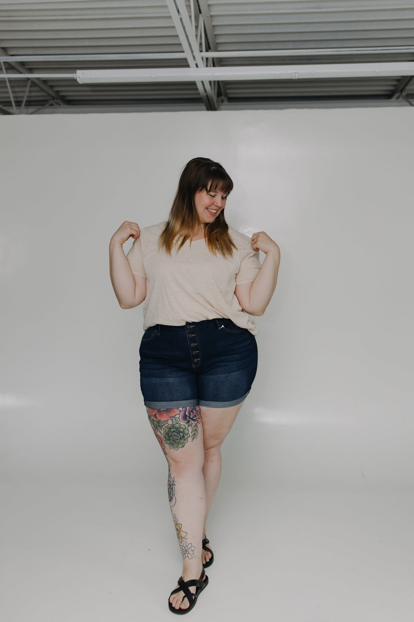 Woman posing in a casual setting with a plain background