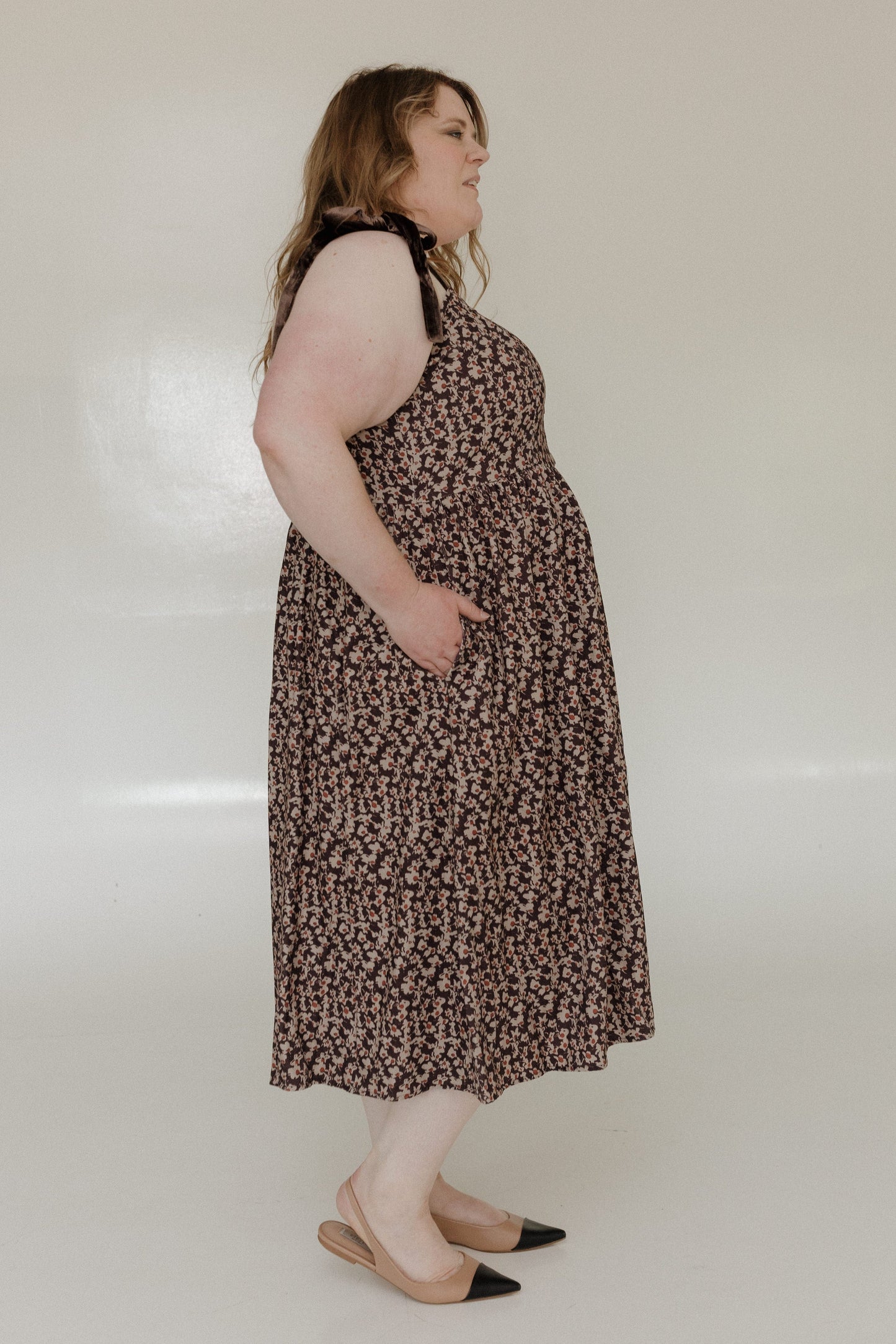 Woman wearing a patterned dress on a plain background