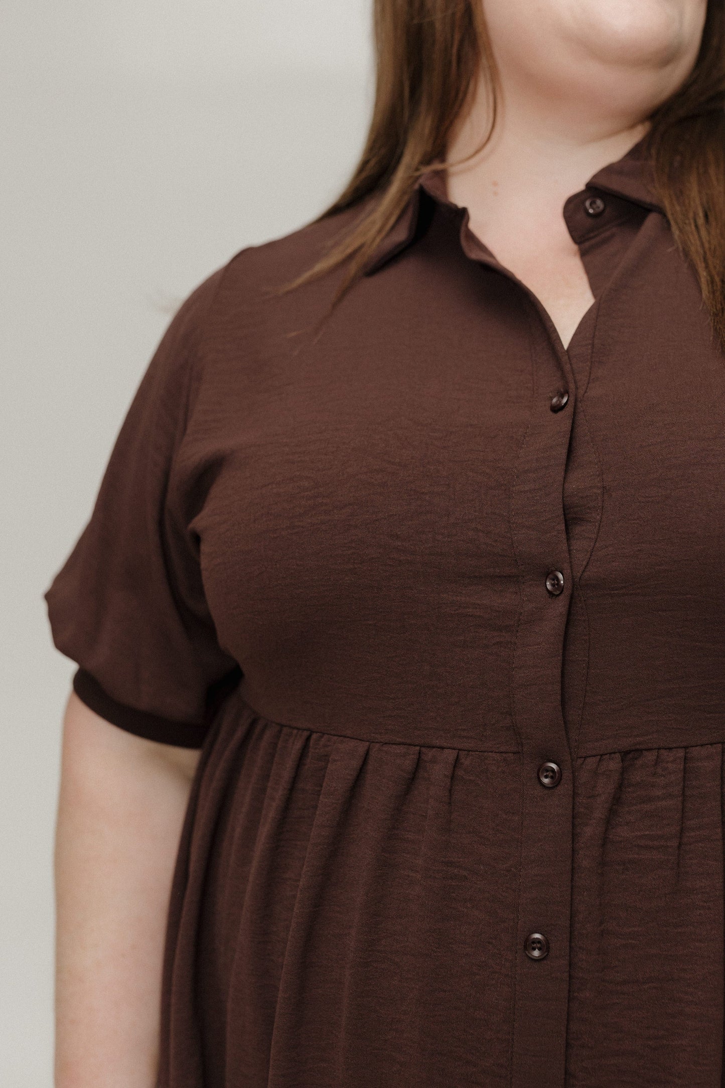 Brown dress worn by a person on a plain background