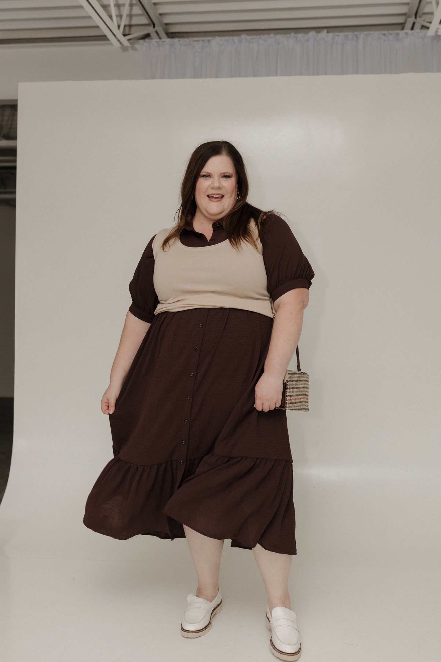 Woman wearing a brown and beige outfit against a white background
