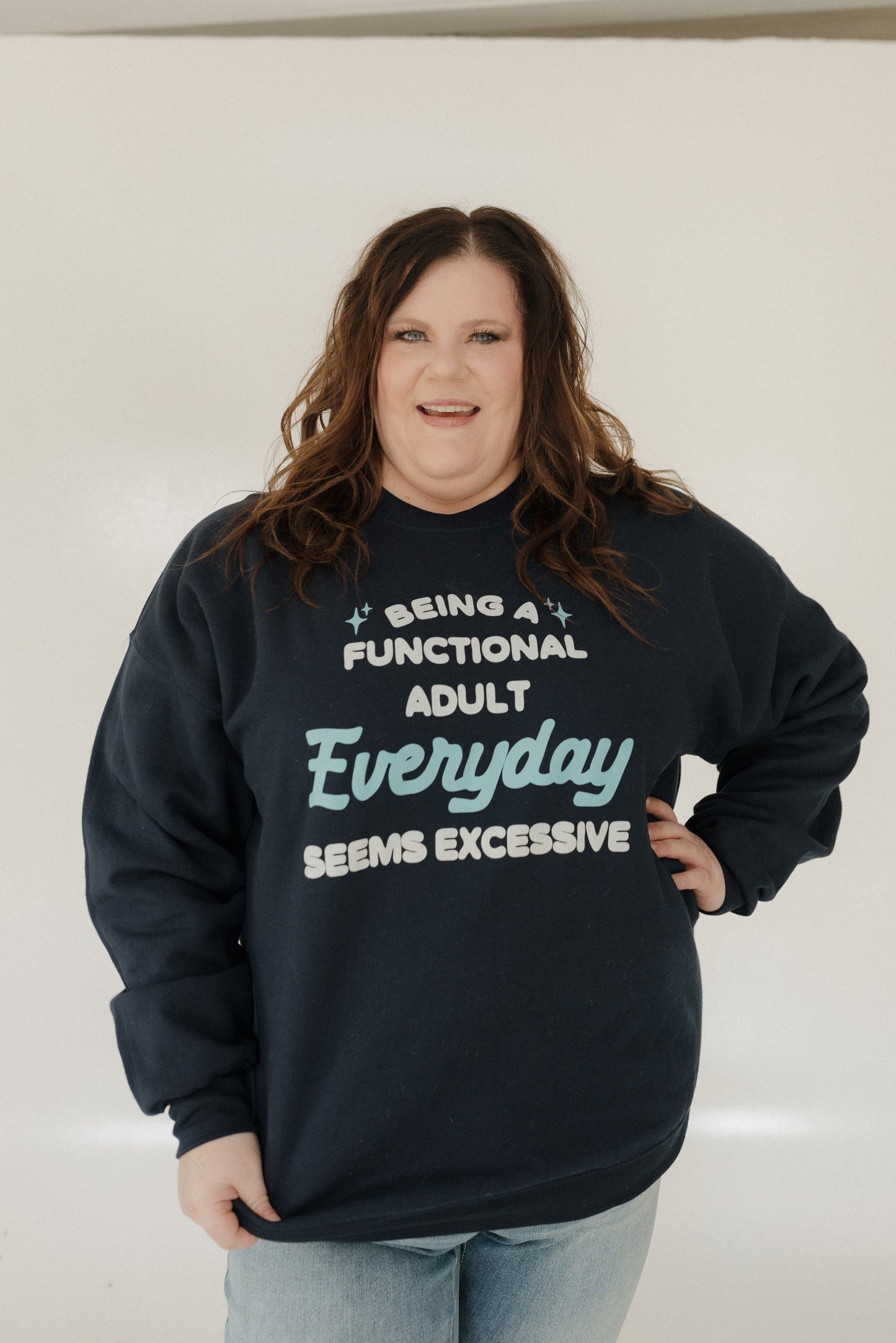 Person wearing a navy sweatshirt with humorous text design against a plain background