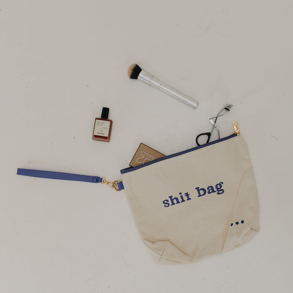 Beige pouch with 'shit bag' text on a white background