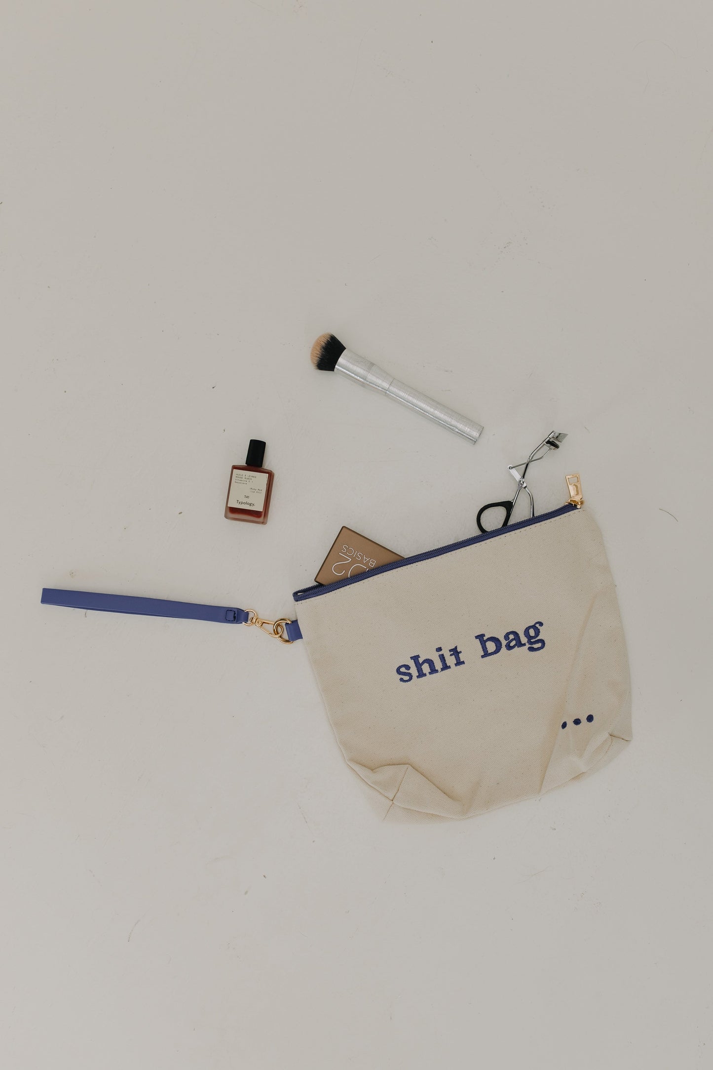 Beige pouch with 'shit bag' text on a white background
