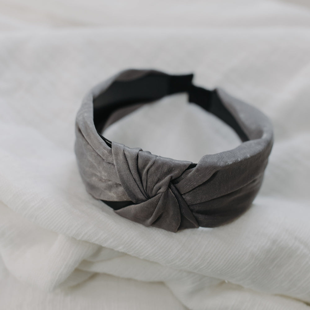 Gray knotted headband on a white fabric background