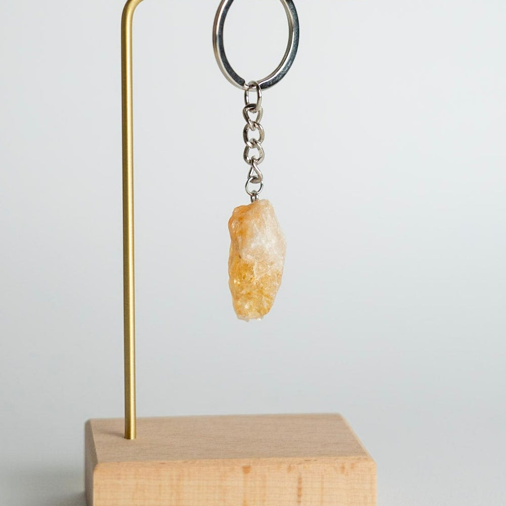 Keychain with a stone pendant on a wooden stand against a light background