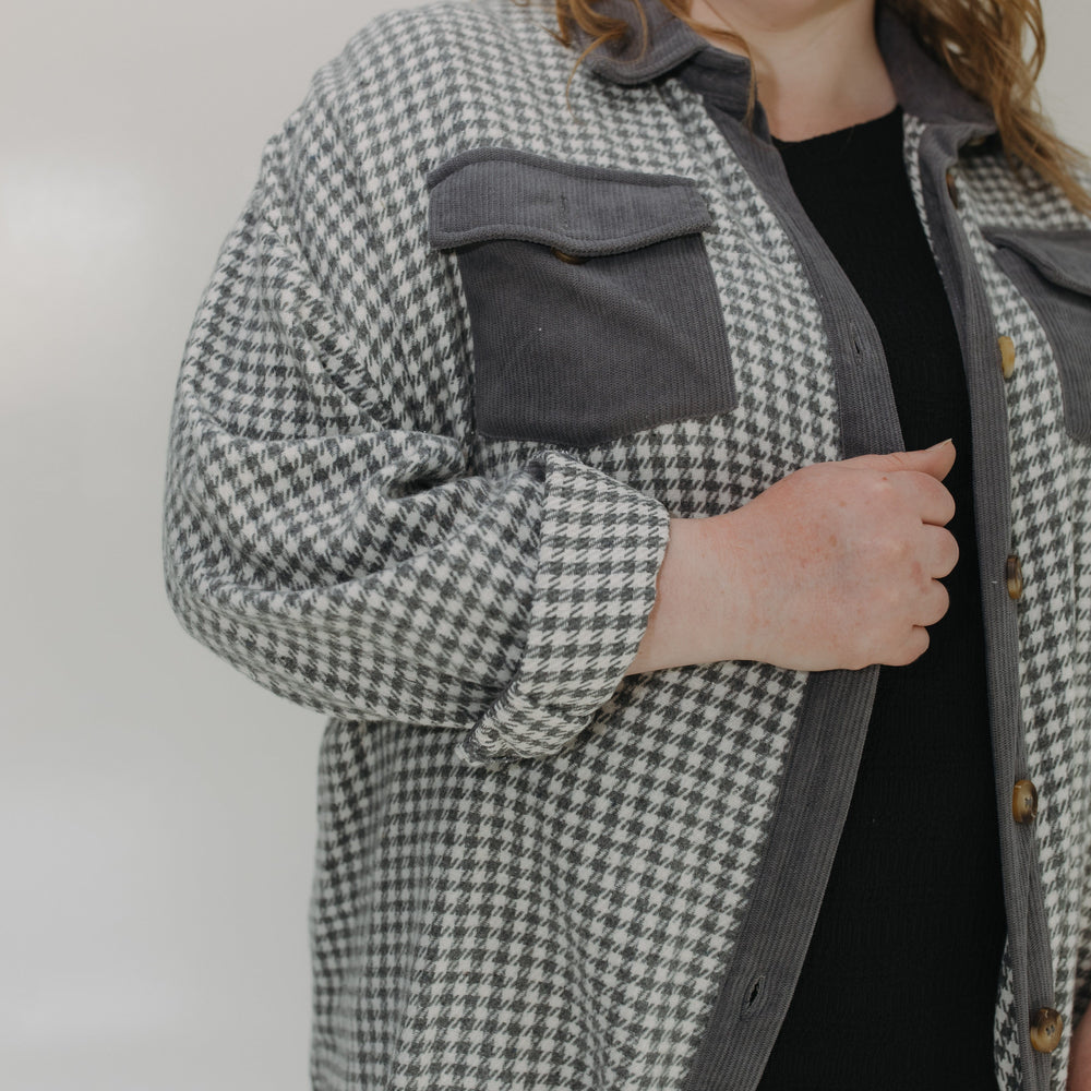 Person wearing a checkered jacket with a plain background