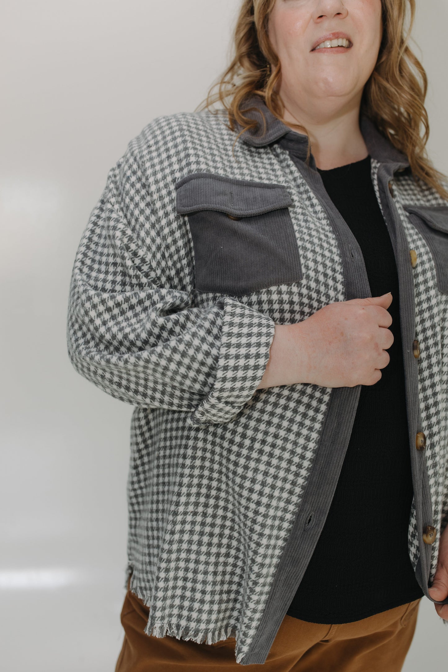 Person wearing a checkered jacket with a plain background