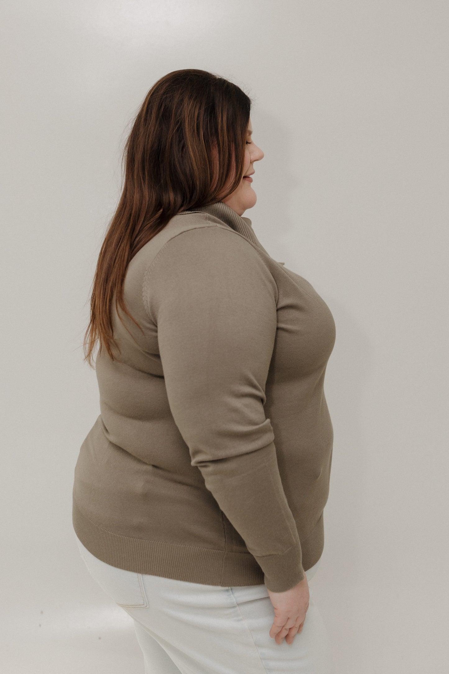 Woman wearing a beige jacket against a plain background