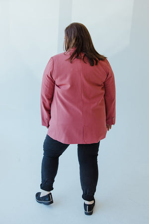 A person stands with their back to the camera, making a timelessly chic statement in a Yesta CLASSIC NOTCHED BLAZER in pink, paired with black pants and sleek black shoes.