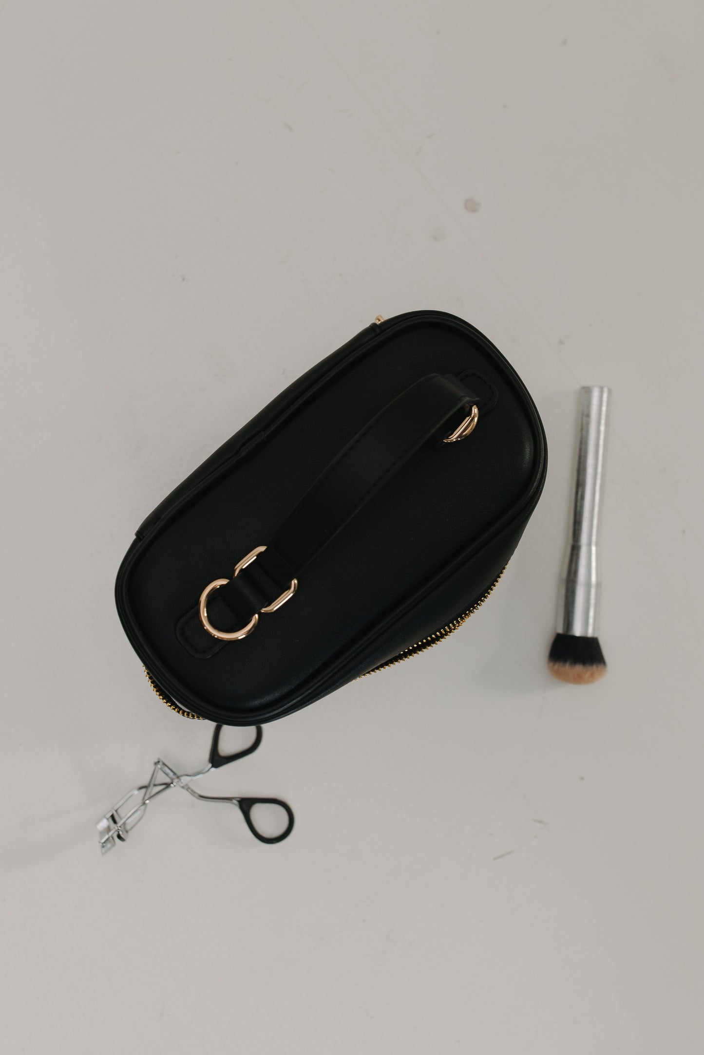 Top of black handbag against a white background