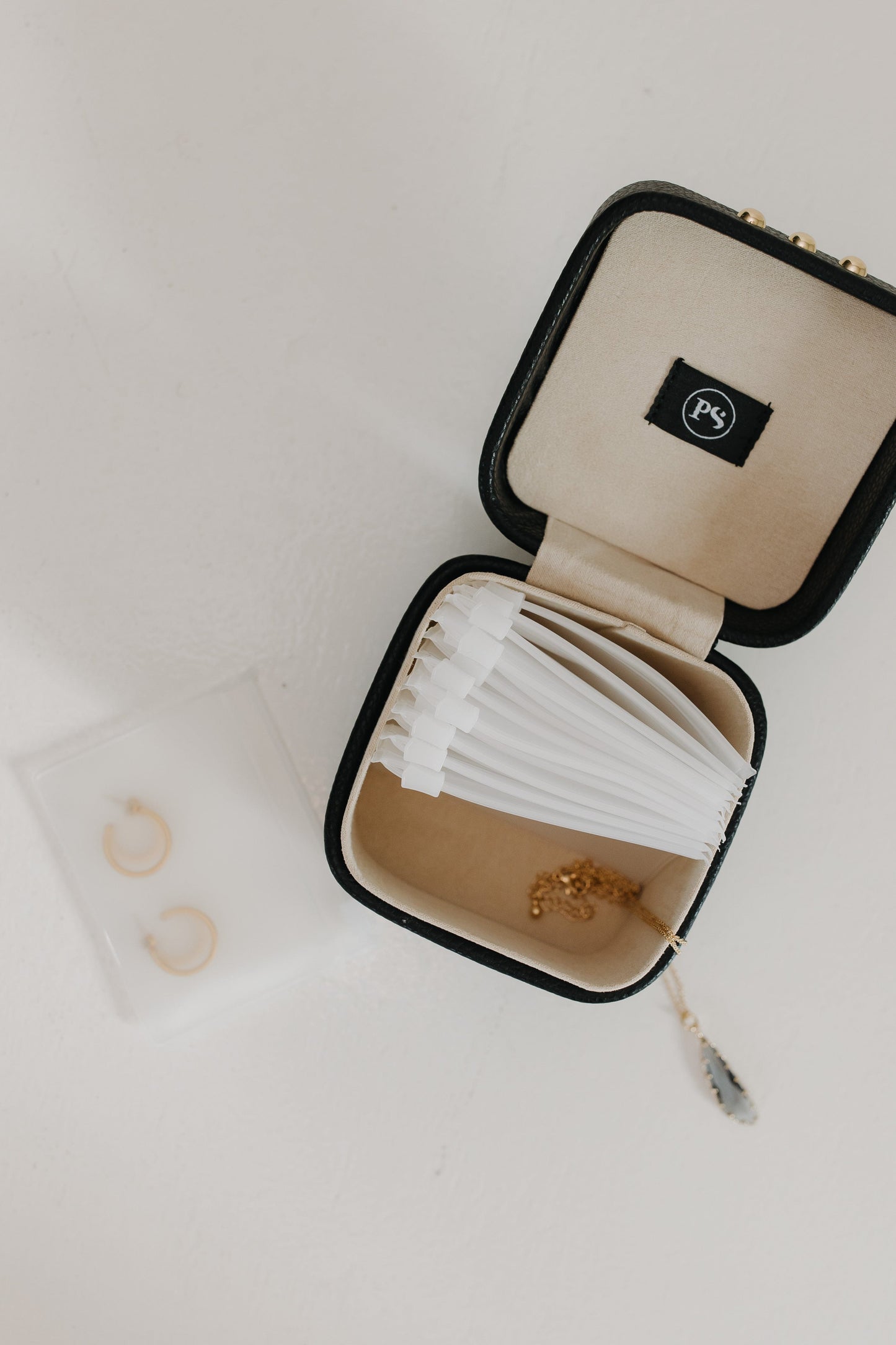 Open jewelry box with jewelry on a light background