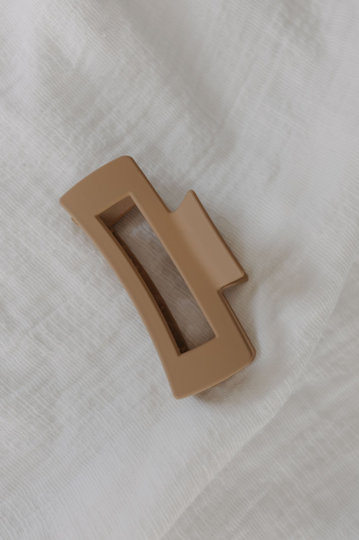 Cool Sand plastic clip on a white textured background