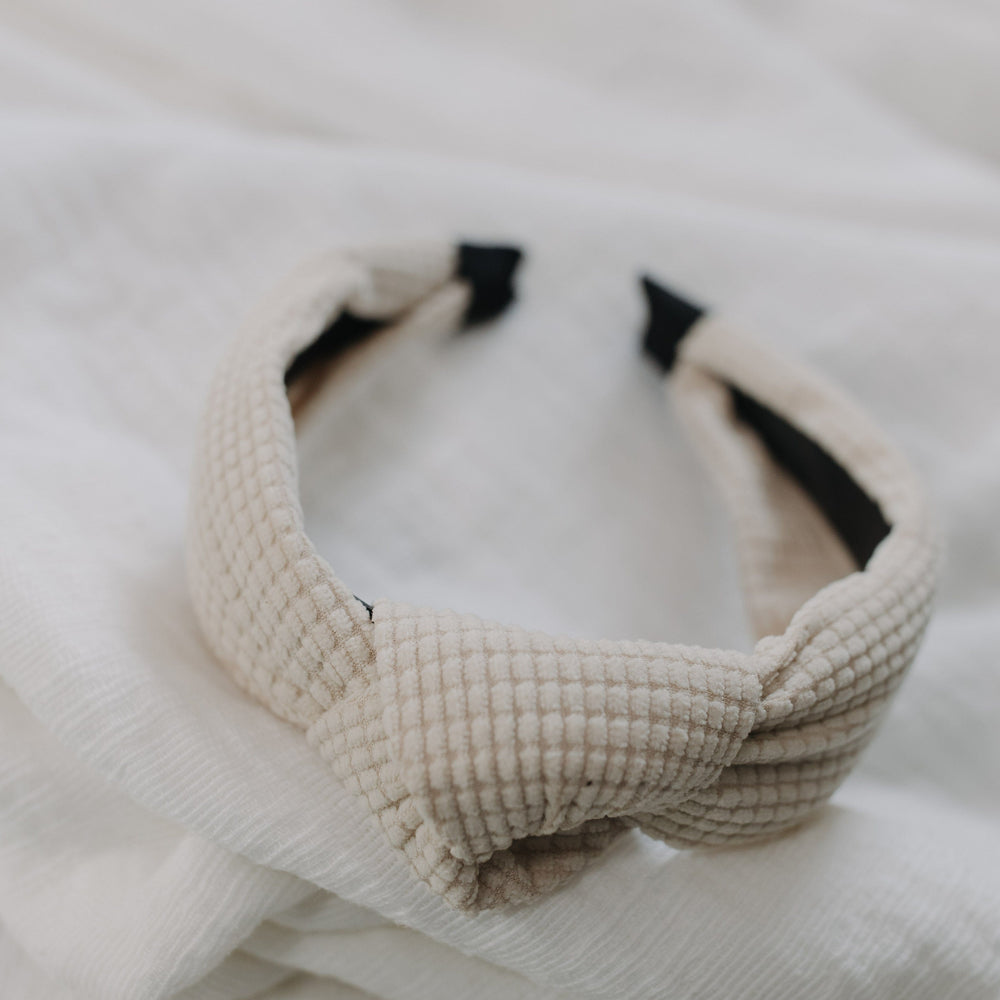 Cream waffle texture headband against a white background. 