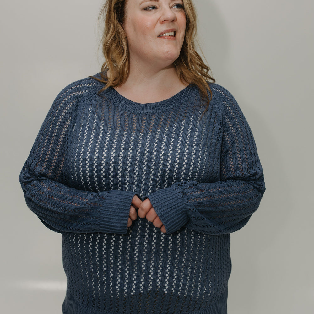 Woman wearing a blue patterned sweater against a plain background