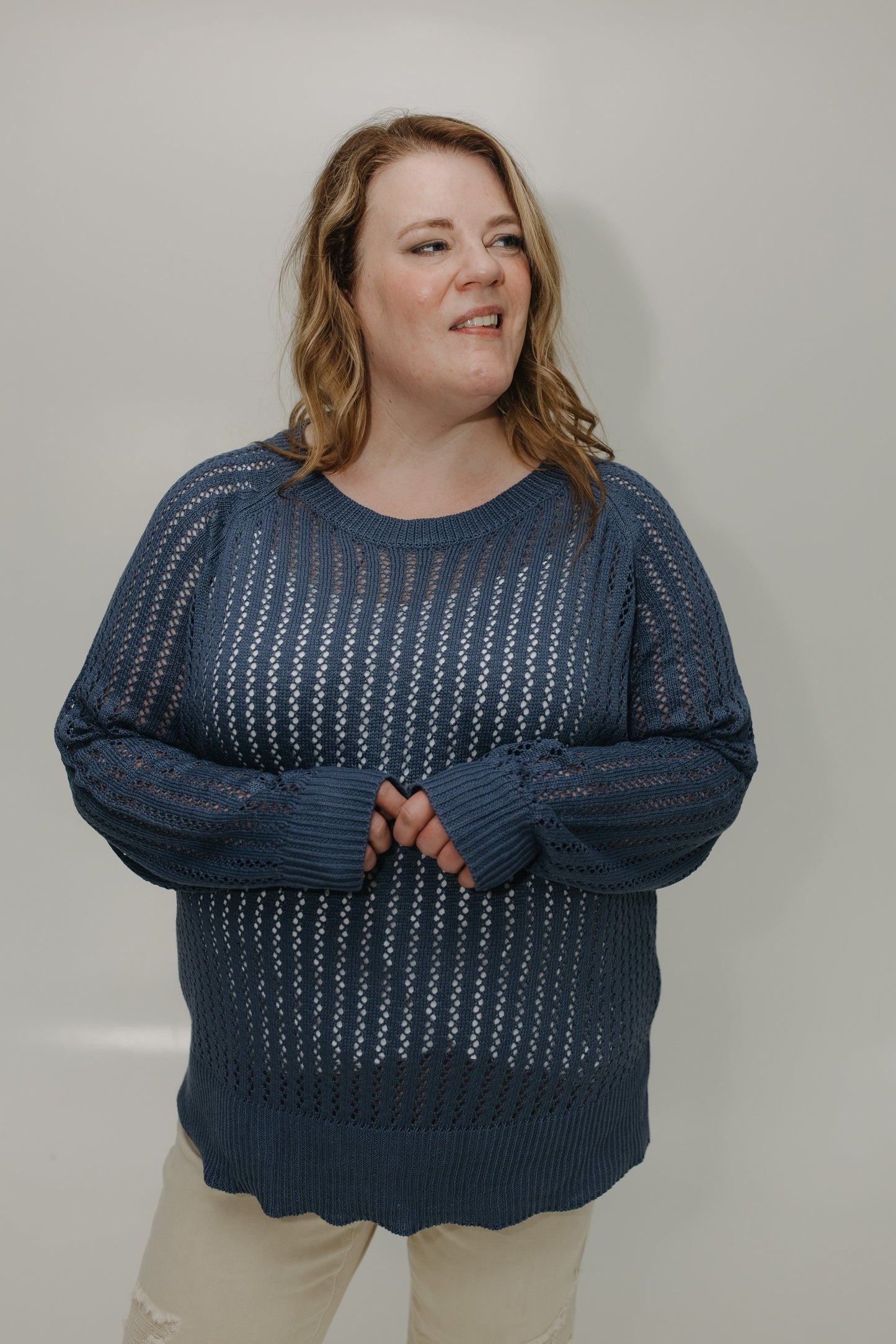 Woman wearing a blue patterned sweater against a plain background