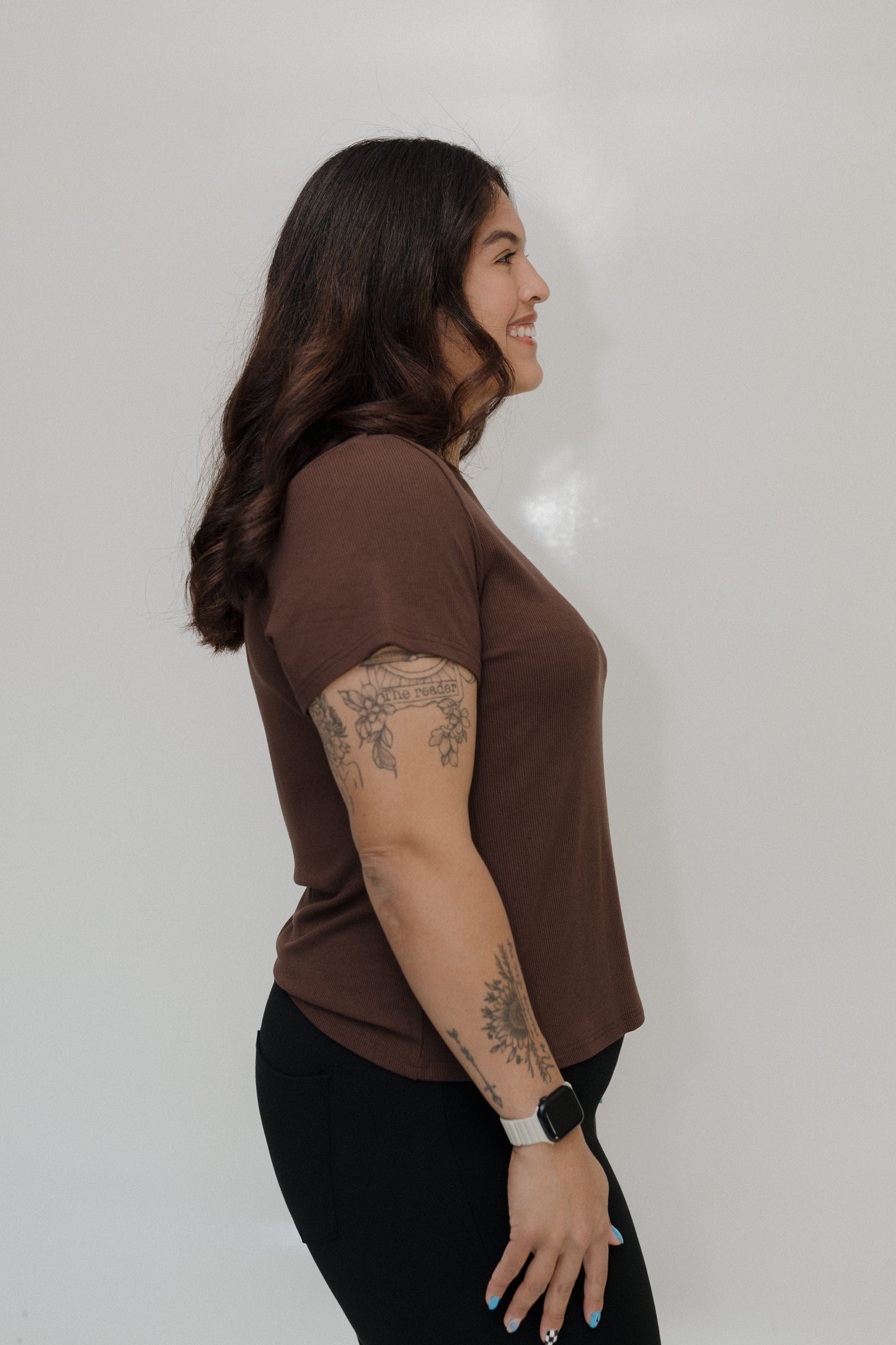 Woman wearing a brown t-shirt against a plain background