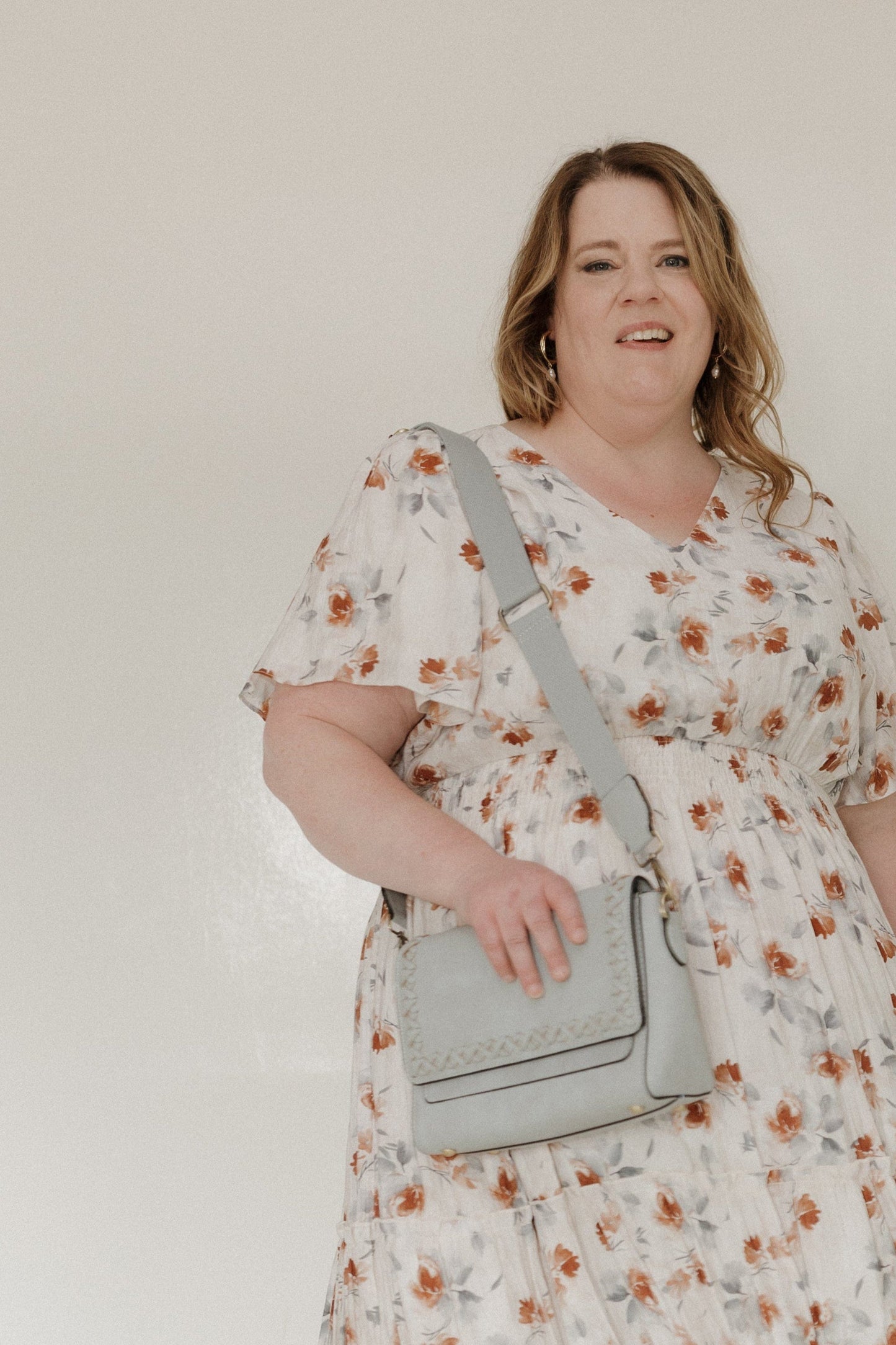 This stylish handbag features a vegan faux leather construction with a dusty blue finish. The flap-over top is secured with a strong magnetic closure, plus an added back zipper pocket for extra storage. Whipstitch detail adds a touch of texture, while the adjustable and removable shoulder strap allows for easy portability