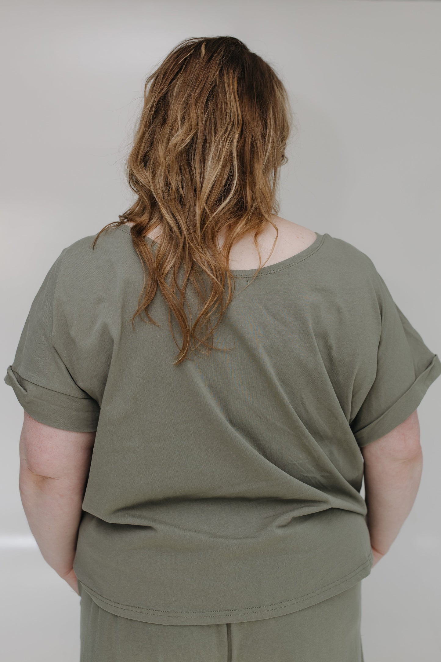 Person wearing a green outfit against a plain background