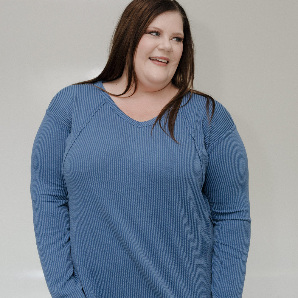 Woman wearing a blue tee against a plain background
