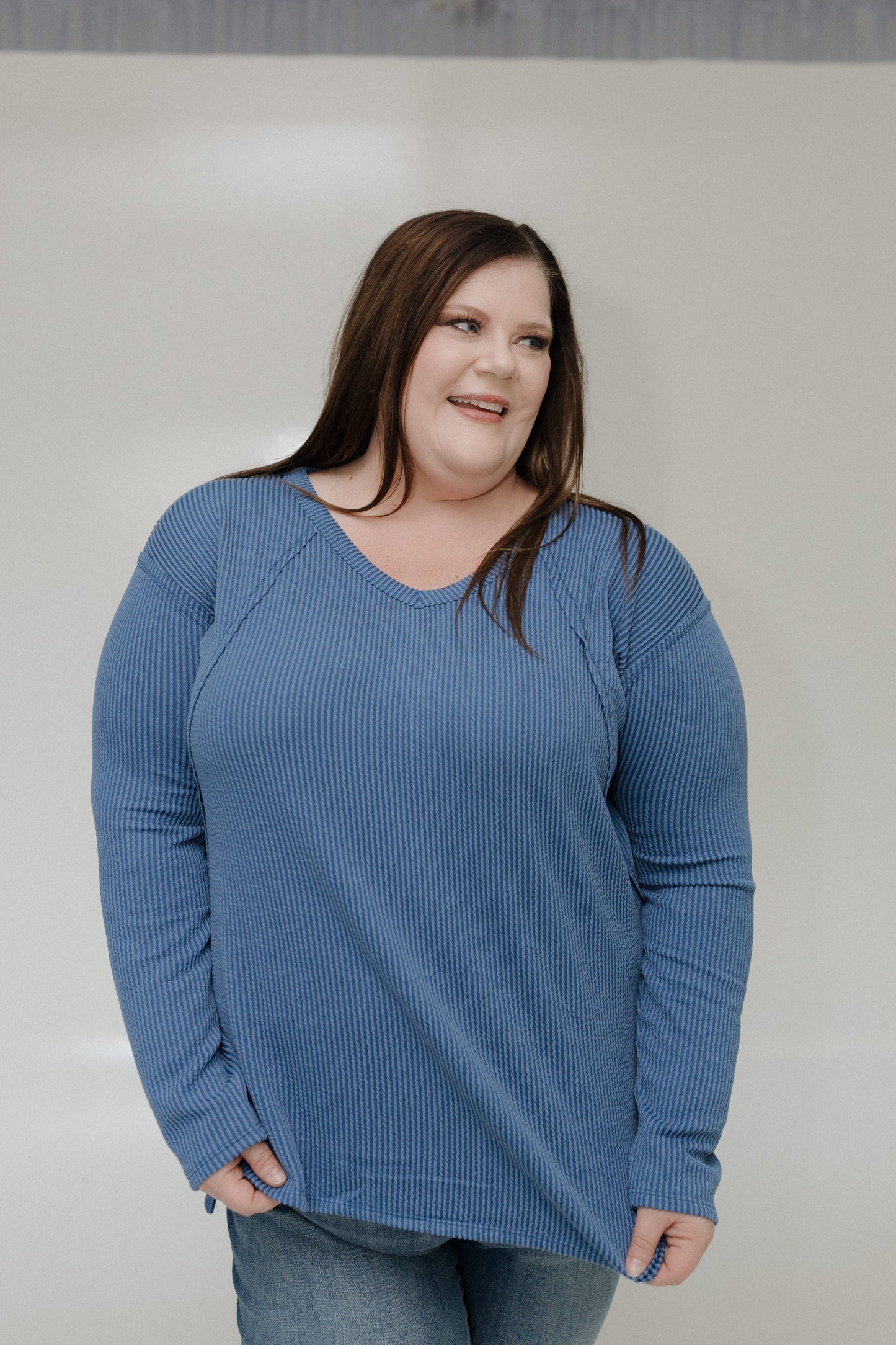 Woman wearing a blue tee against a plain background