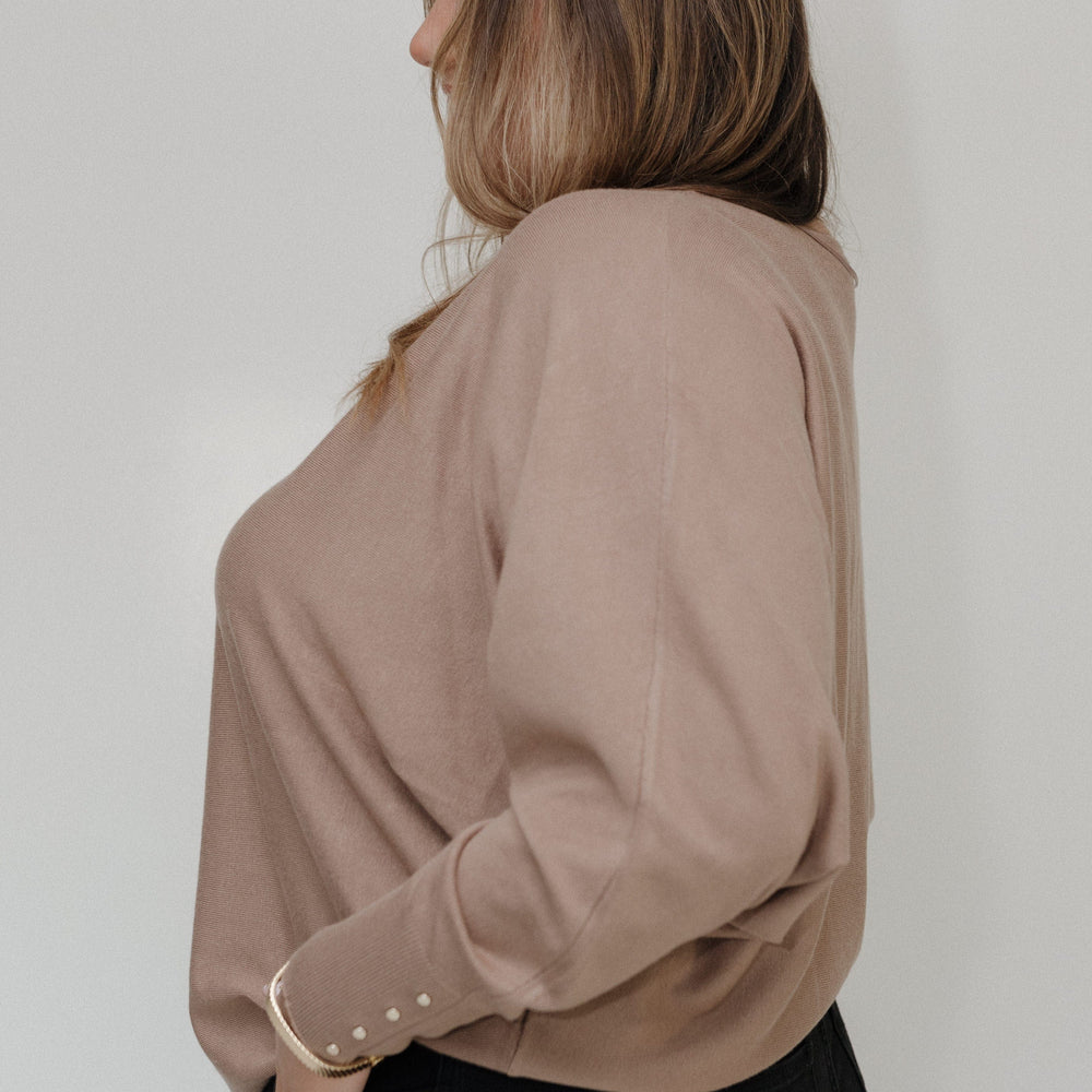 Woman wearing a beige blouse against a white background
