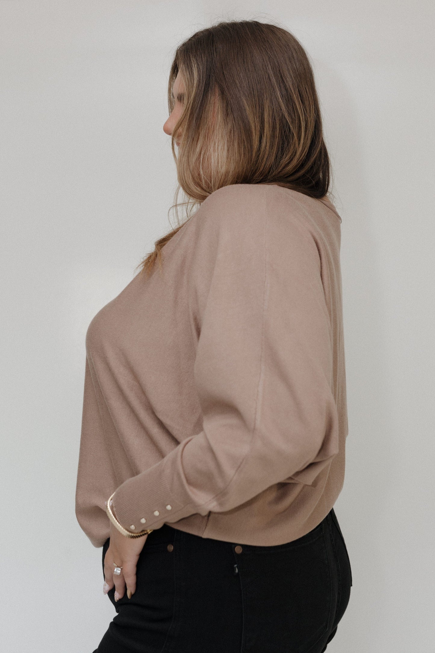 Woman wearing a beige blouse against a white background