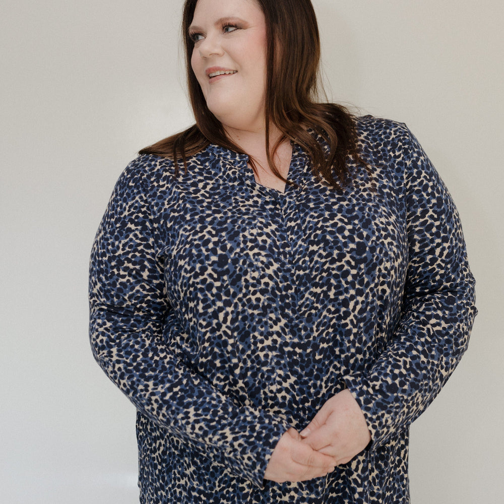 Woman wearing a blue patterned shirt against a plain background