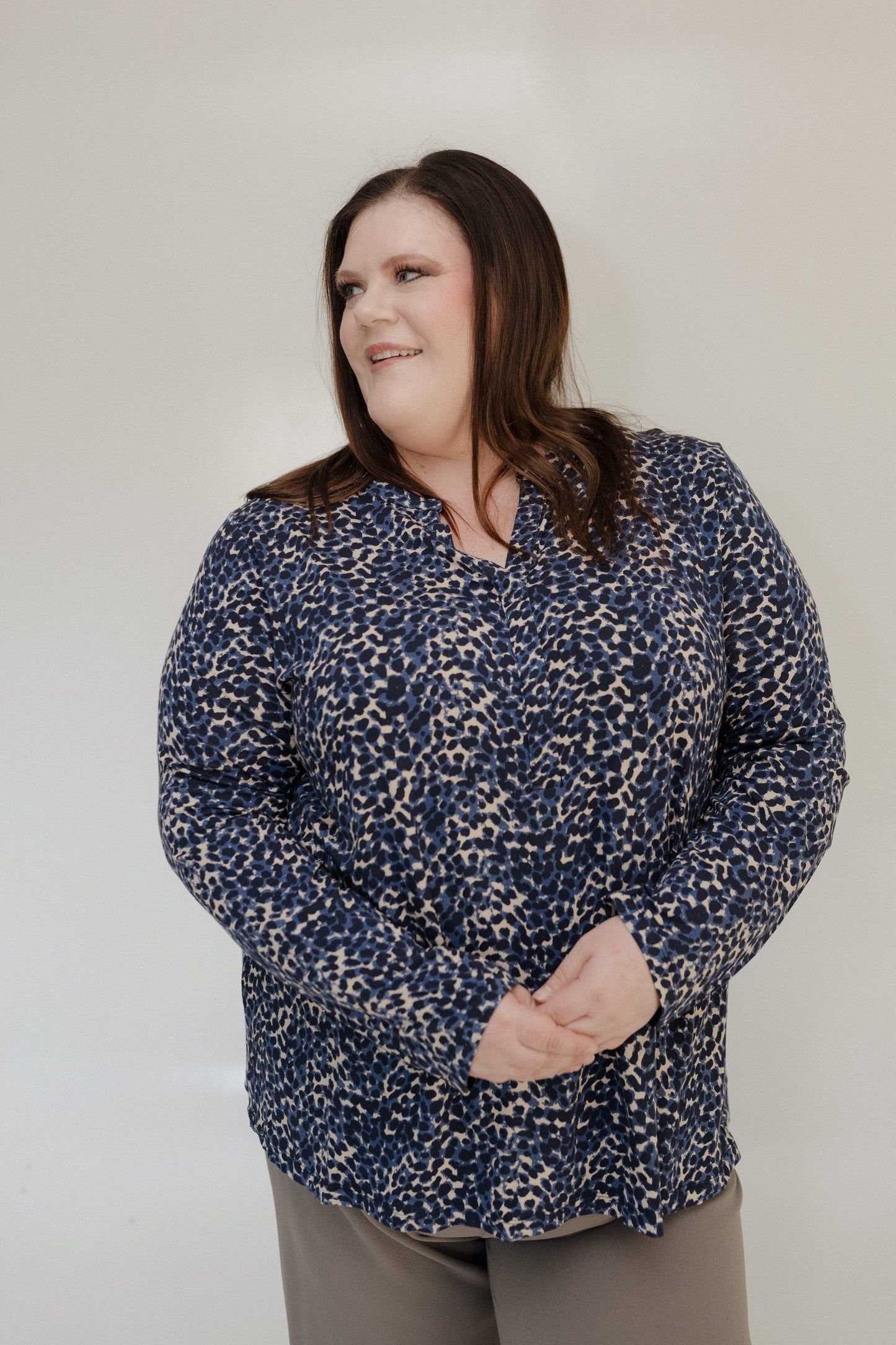 Woman wearing a blue patterned shirt against a plain background