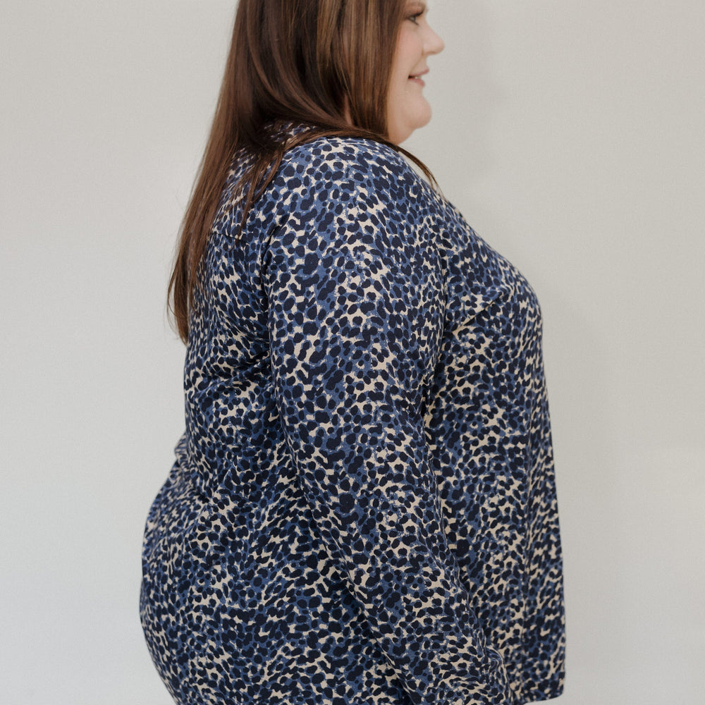 Woman wearing a blue patterned blouse against a plain background