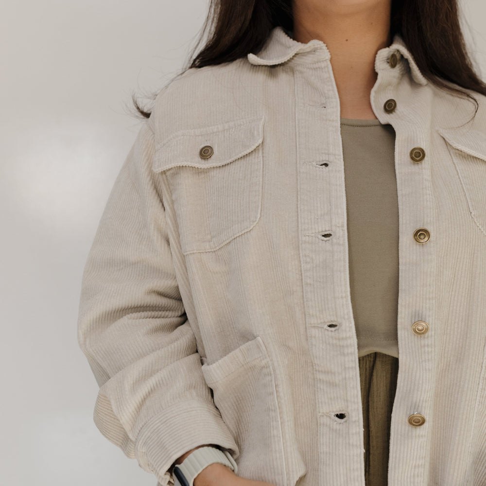 Woman wearing a beige jacket with a plain background