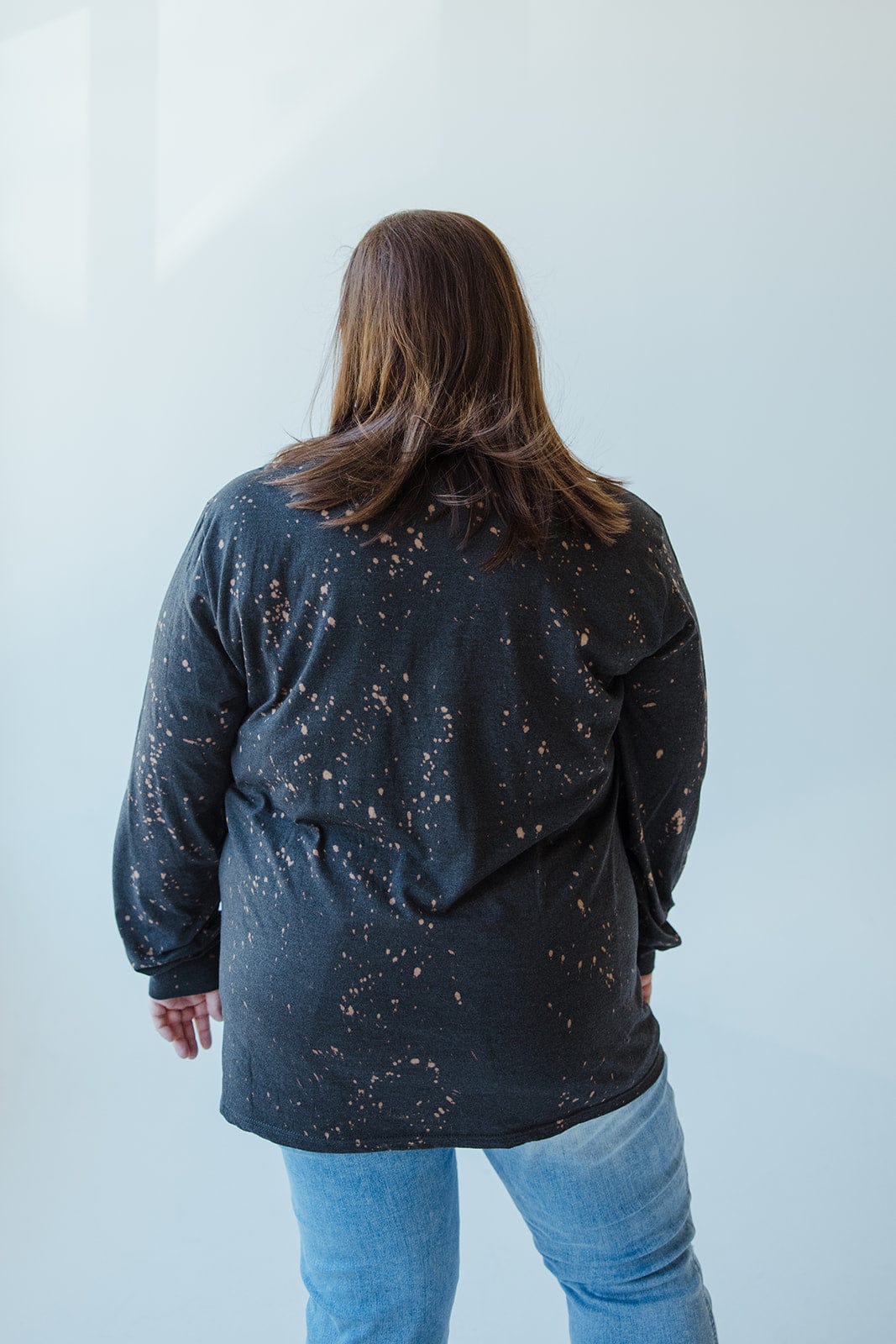 A person with brown hair is wearing a black tee from Love Marlow, the 
