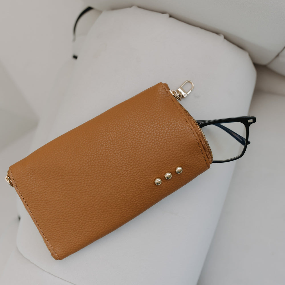 Brown leather wallet with gold accents on a white surface
