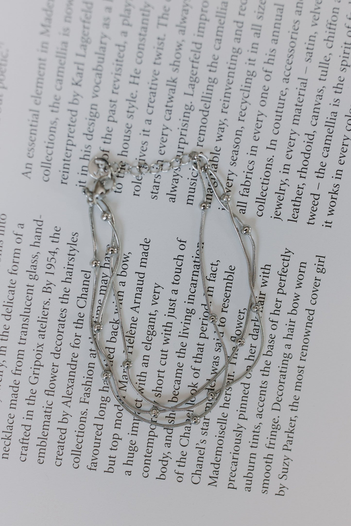Silver bracelet on a book page with text