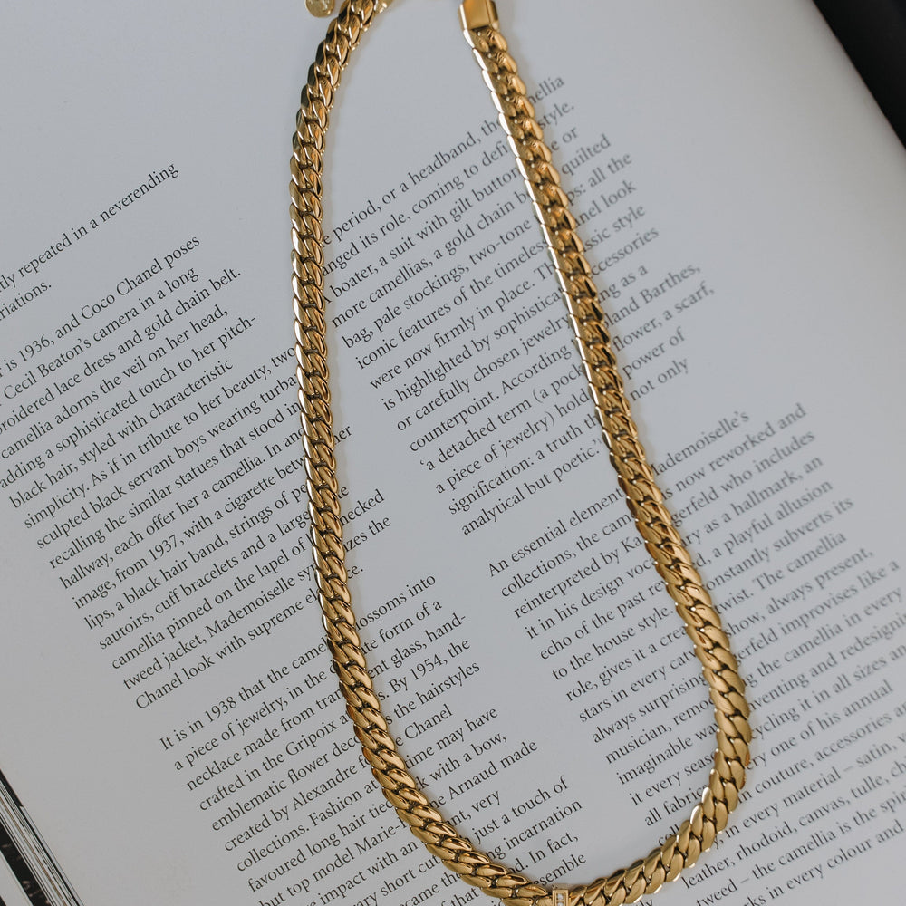 Gold chain necklace on an open book