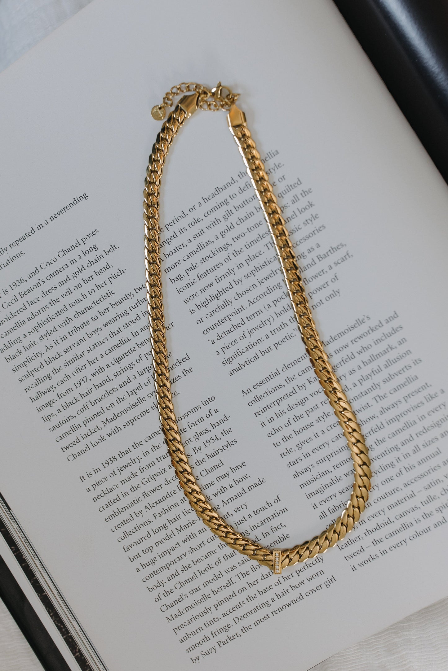Gold chain necklace on an open book