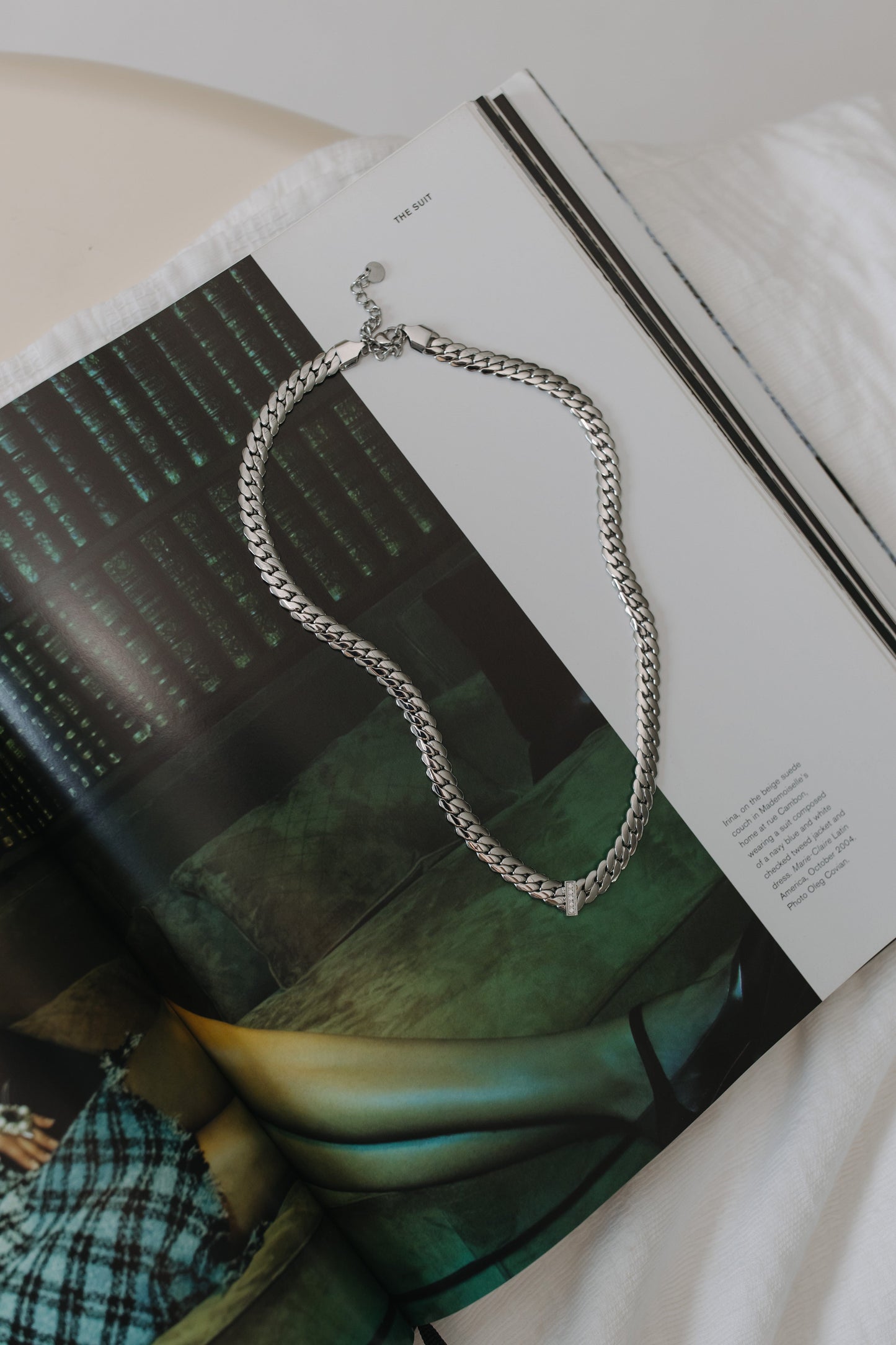Silver chain necklace on a magazine