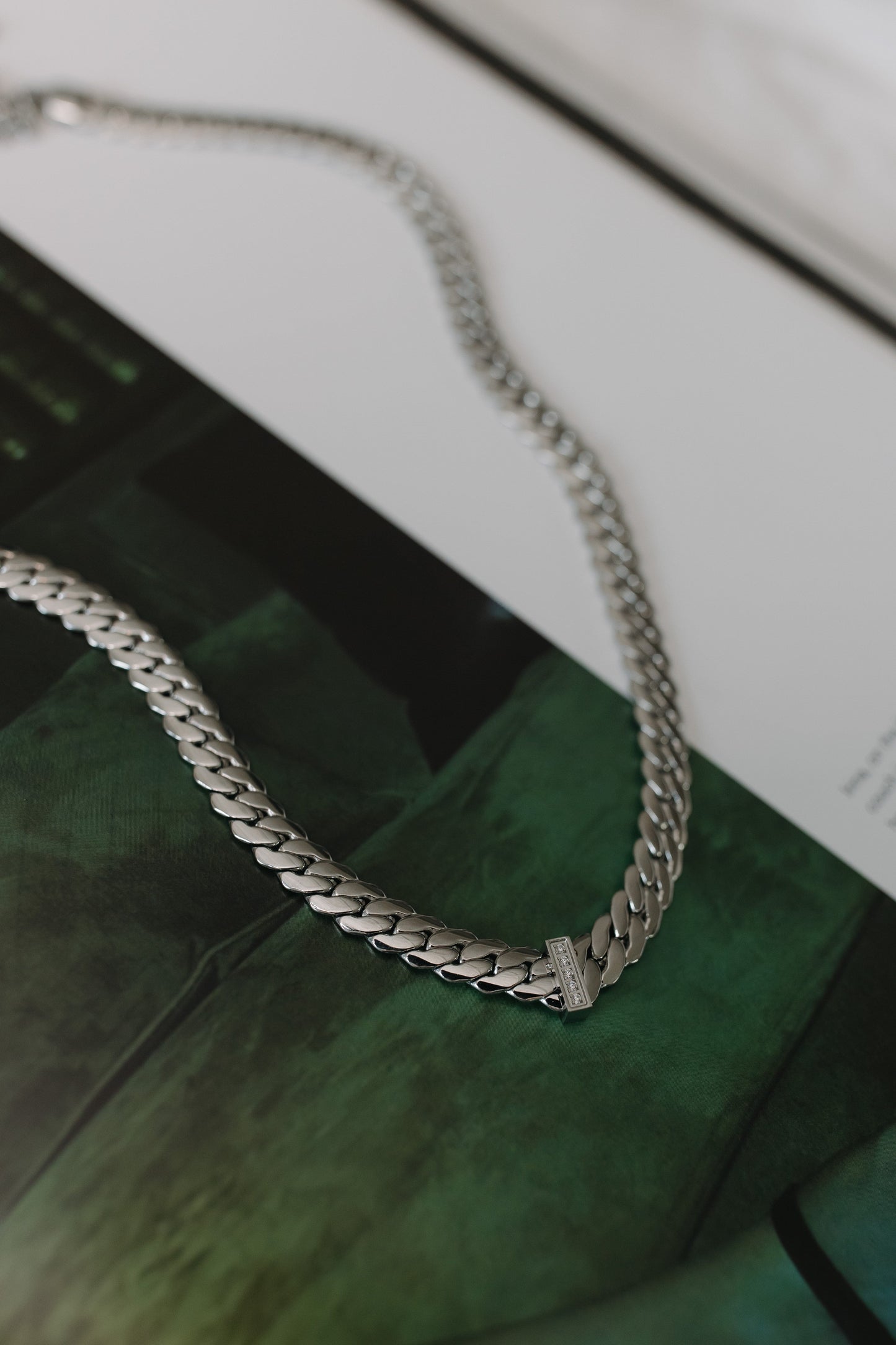 Silver chain necklace on a reflective surface