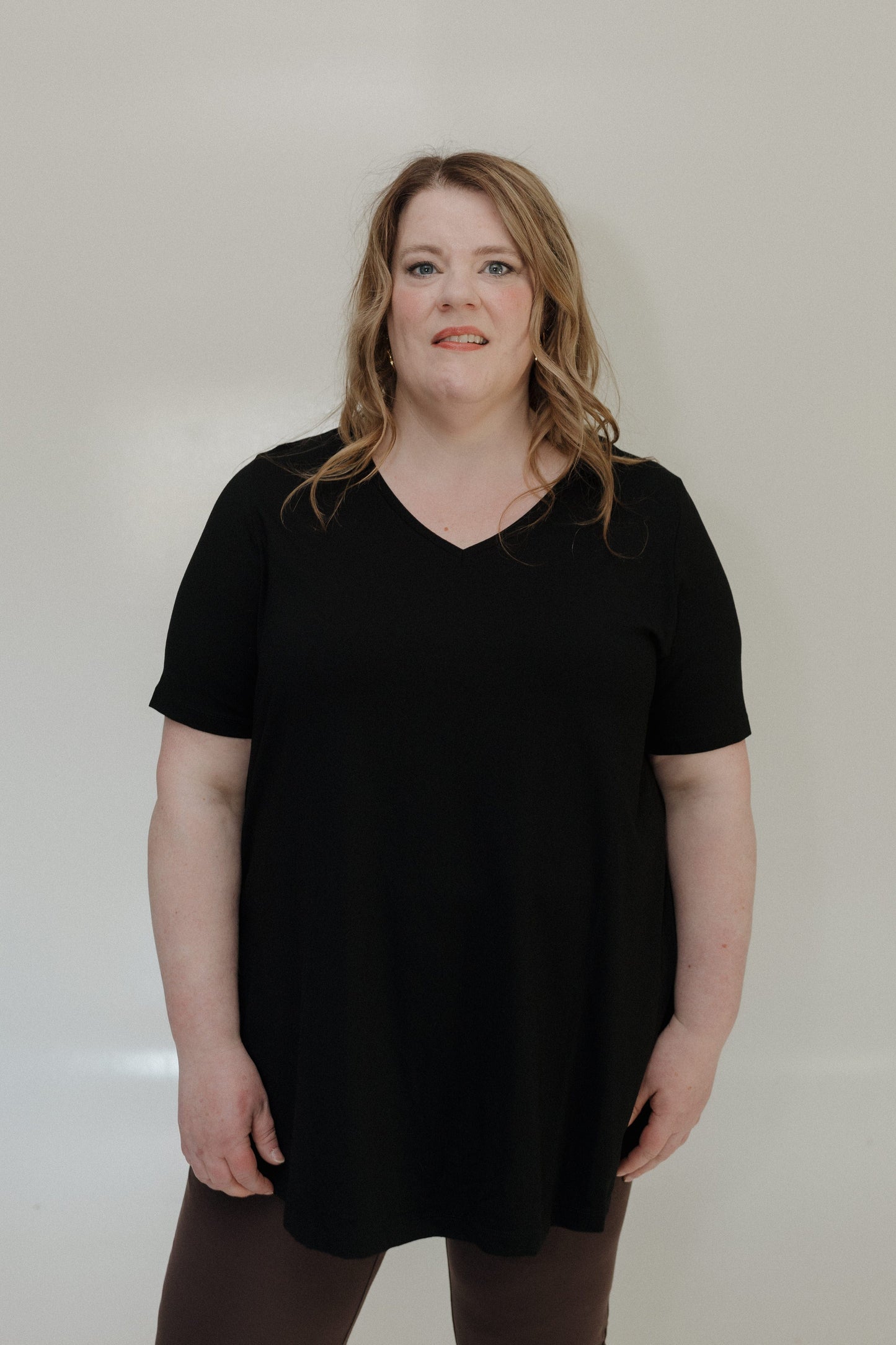 Person wearing a black t-shirt against a plain background