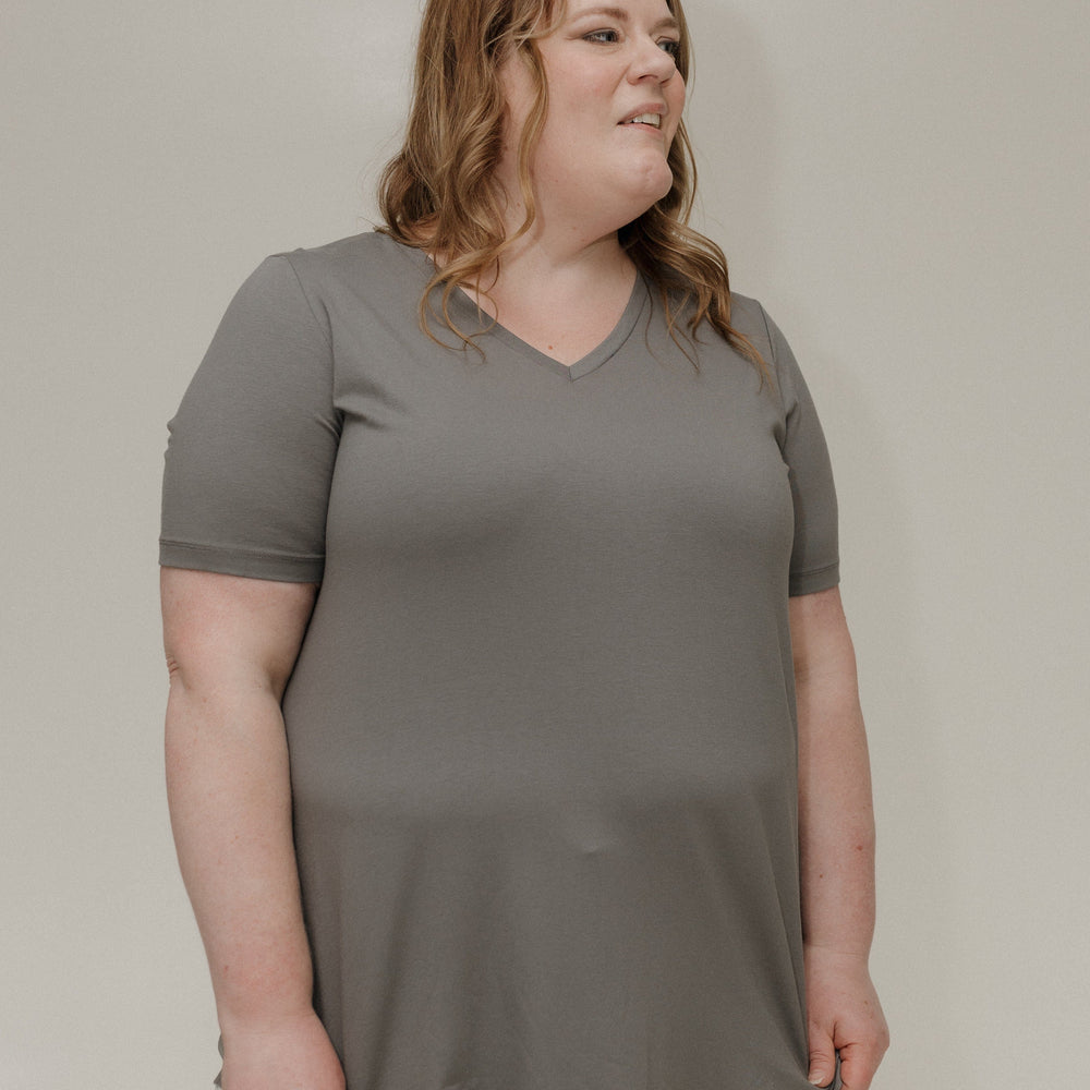 Woman wearing a gray t-shirt against a plain background