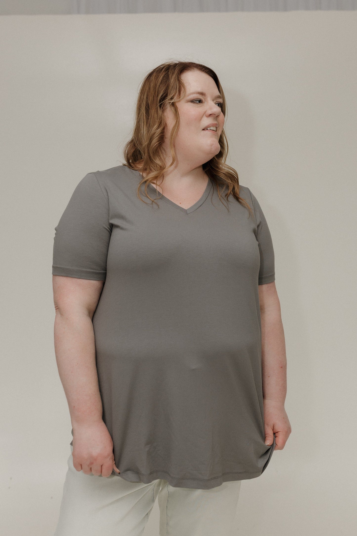 Woman wearing a gray t-shirt against a plain background