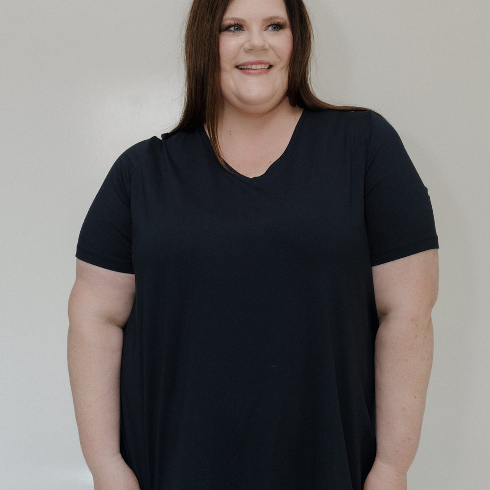 Woman wearing a black t-shirt against a plain background