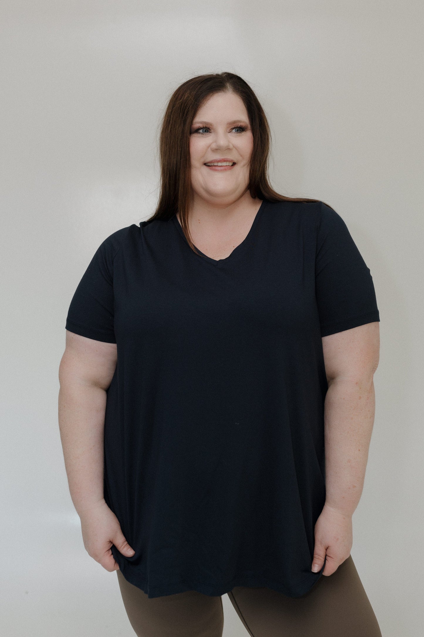 Woman wearing a black t-shirt against a plain background