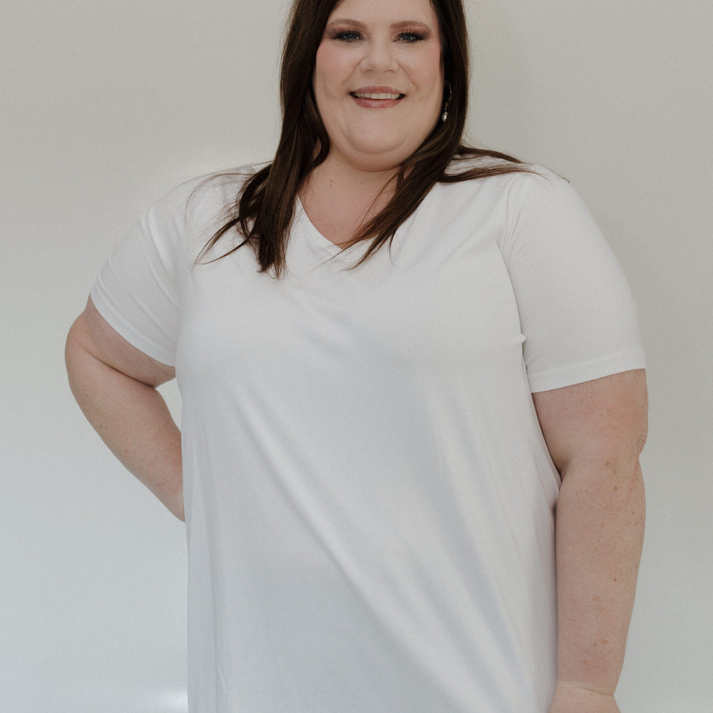 Person wearing a white t-shirt and gray pants against a plain background