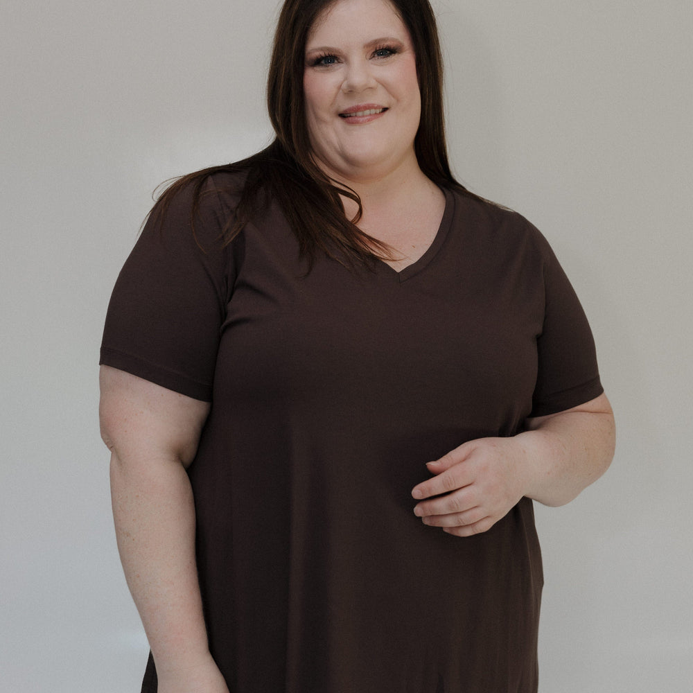 Woman wearing a brown shirt against a plain background
