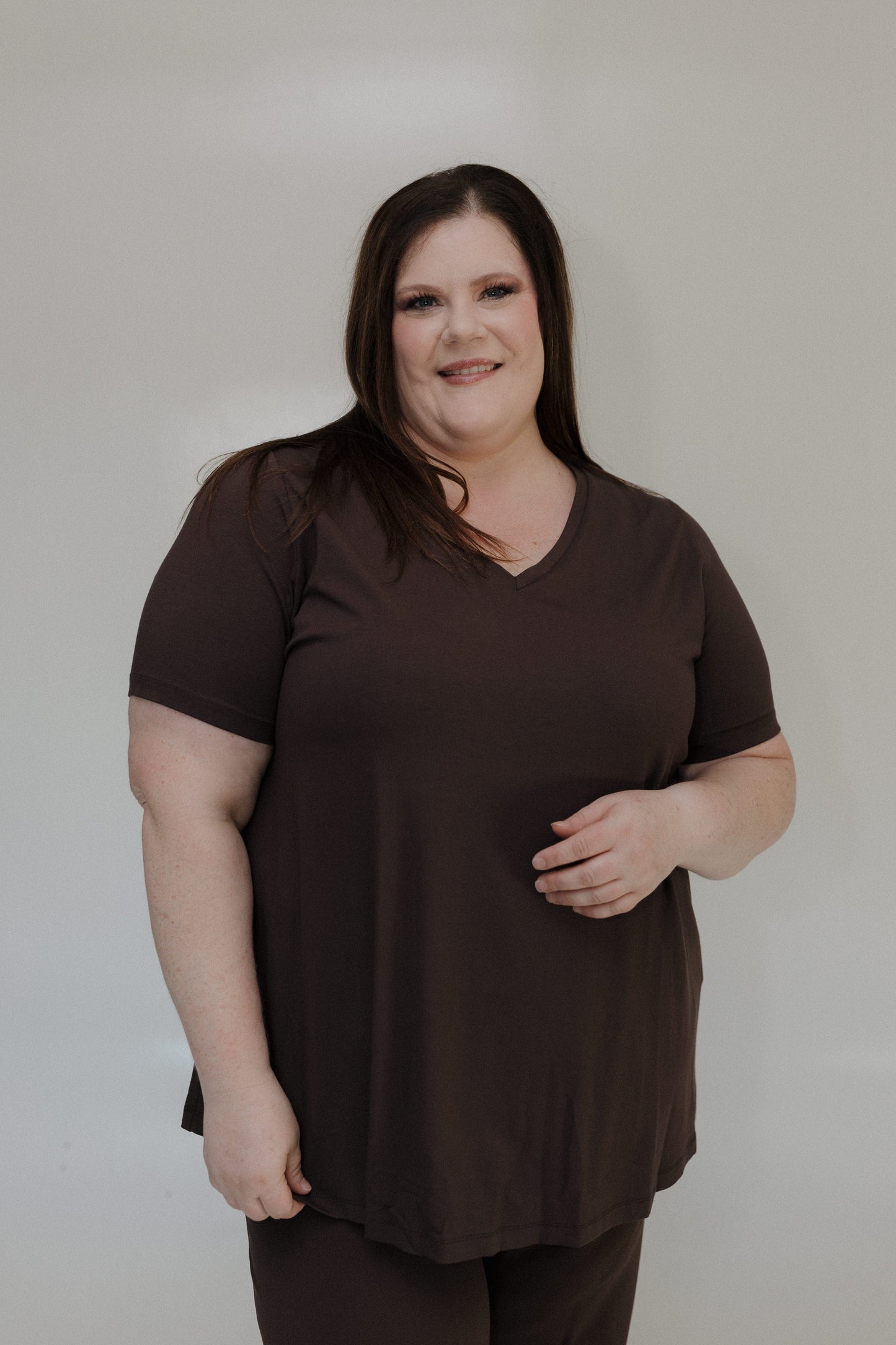 Woman wearing a brown shirt against a plain background