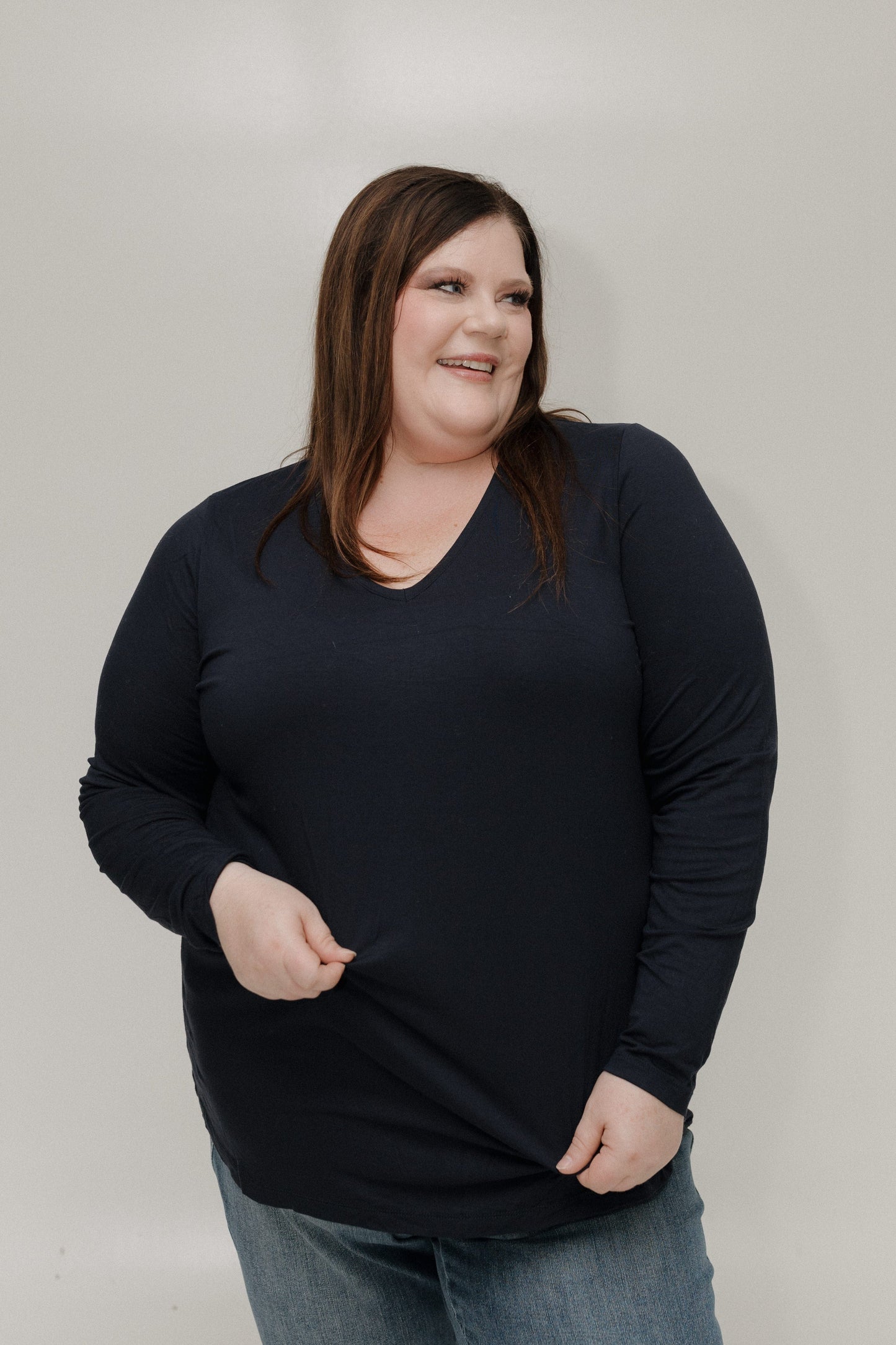 Woman wearing a black long-sleeve shirt against a plain background